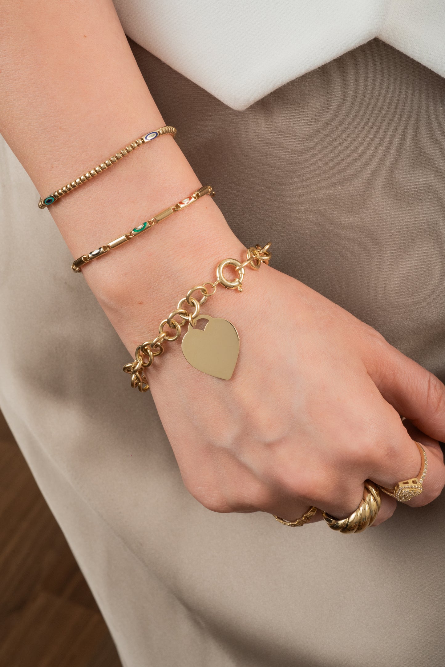 Pulsera de oro sólido en 10 kilates con eslabón cilindrico liso y eslabón con ojo esmaltado intercalados.