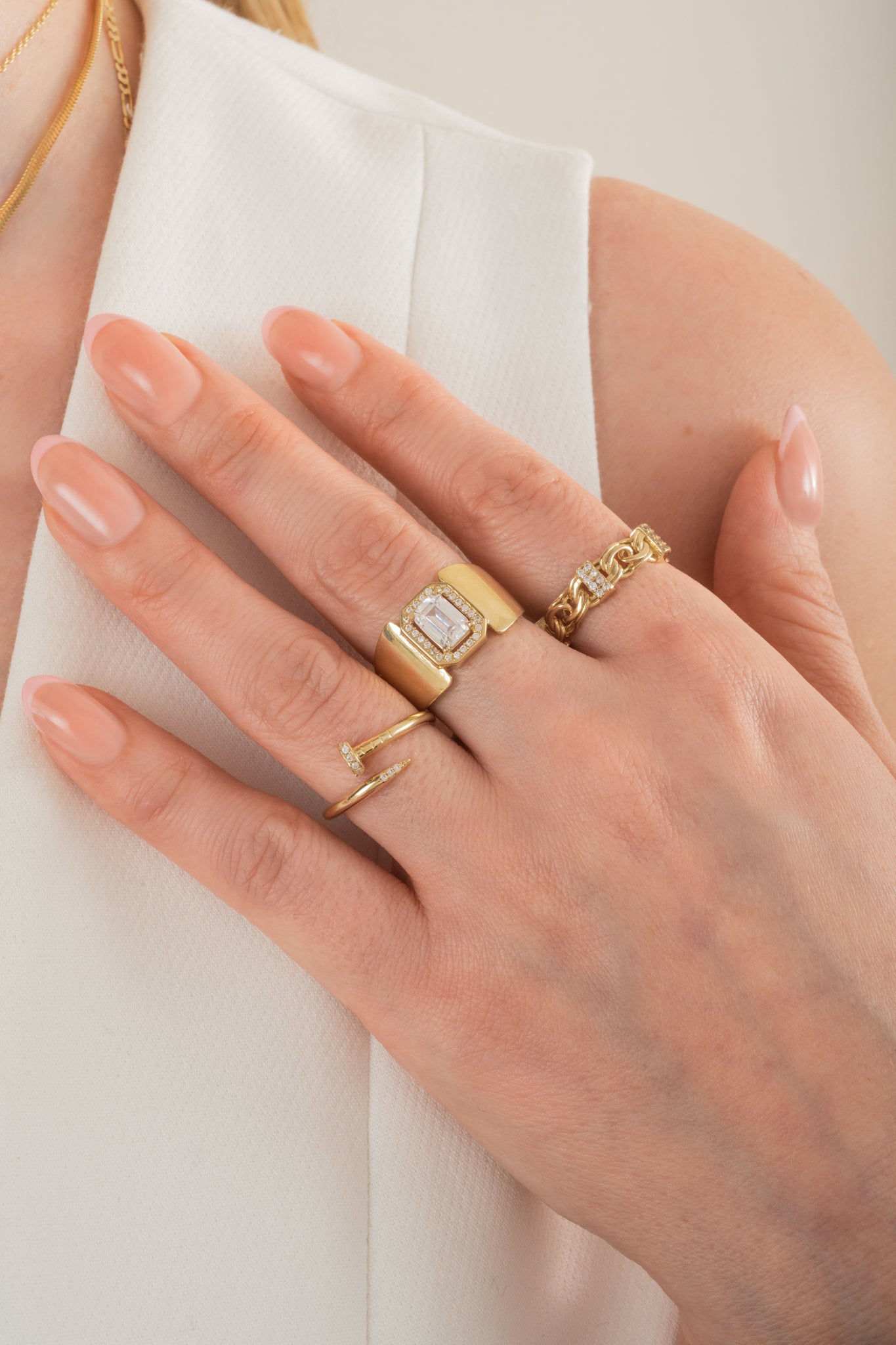 Anillo de oro solido en 10 kilates con un controno liso ancho y en el centro un piedra blanca rectangular con un pequeño contorno de zirconias