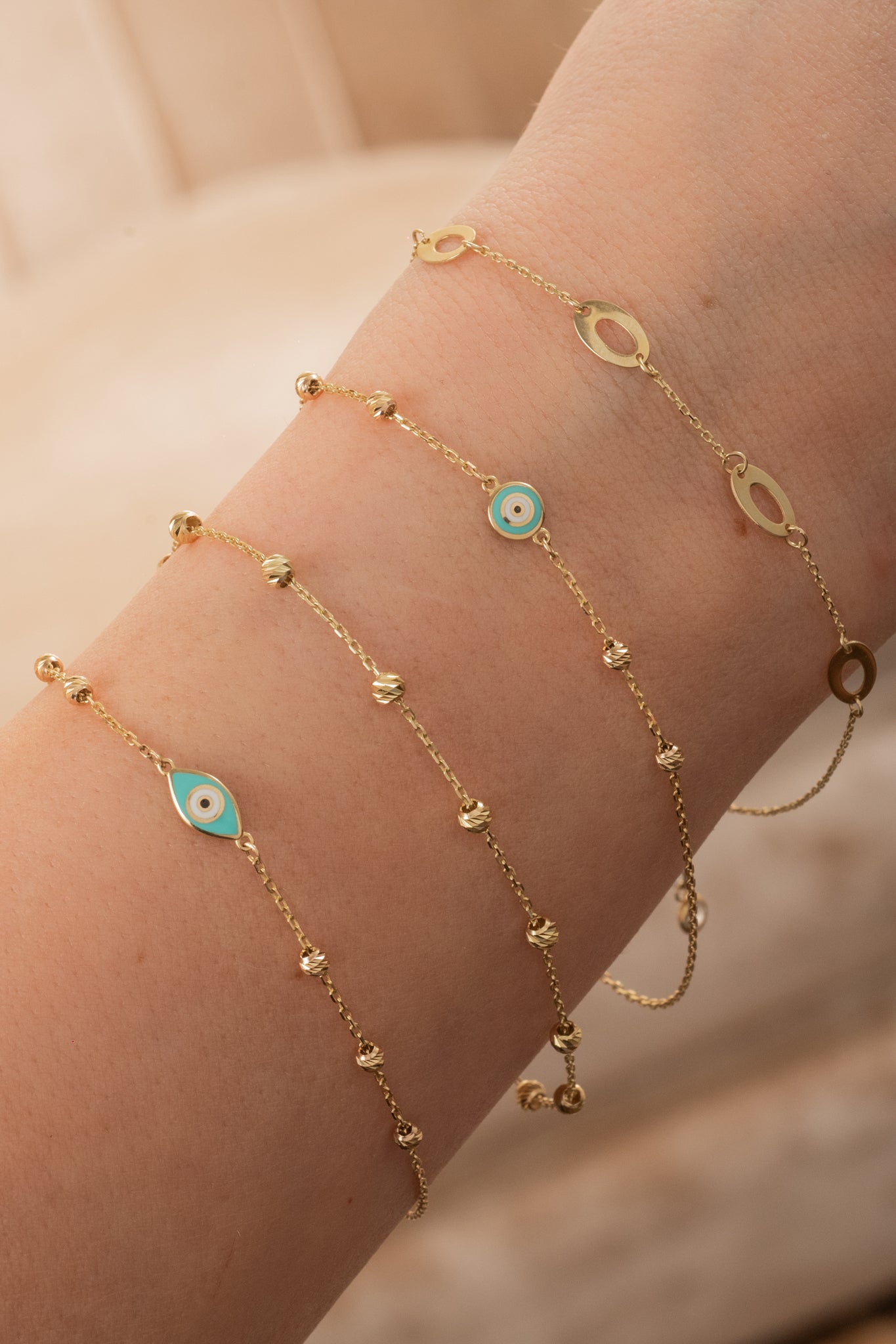 Pulsera de oro sólido en 10 kilates con bolitas diamantadas y ojo circular esmaltado.