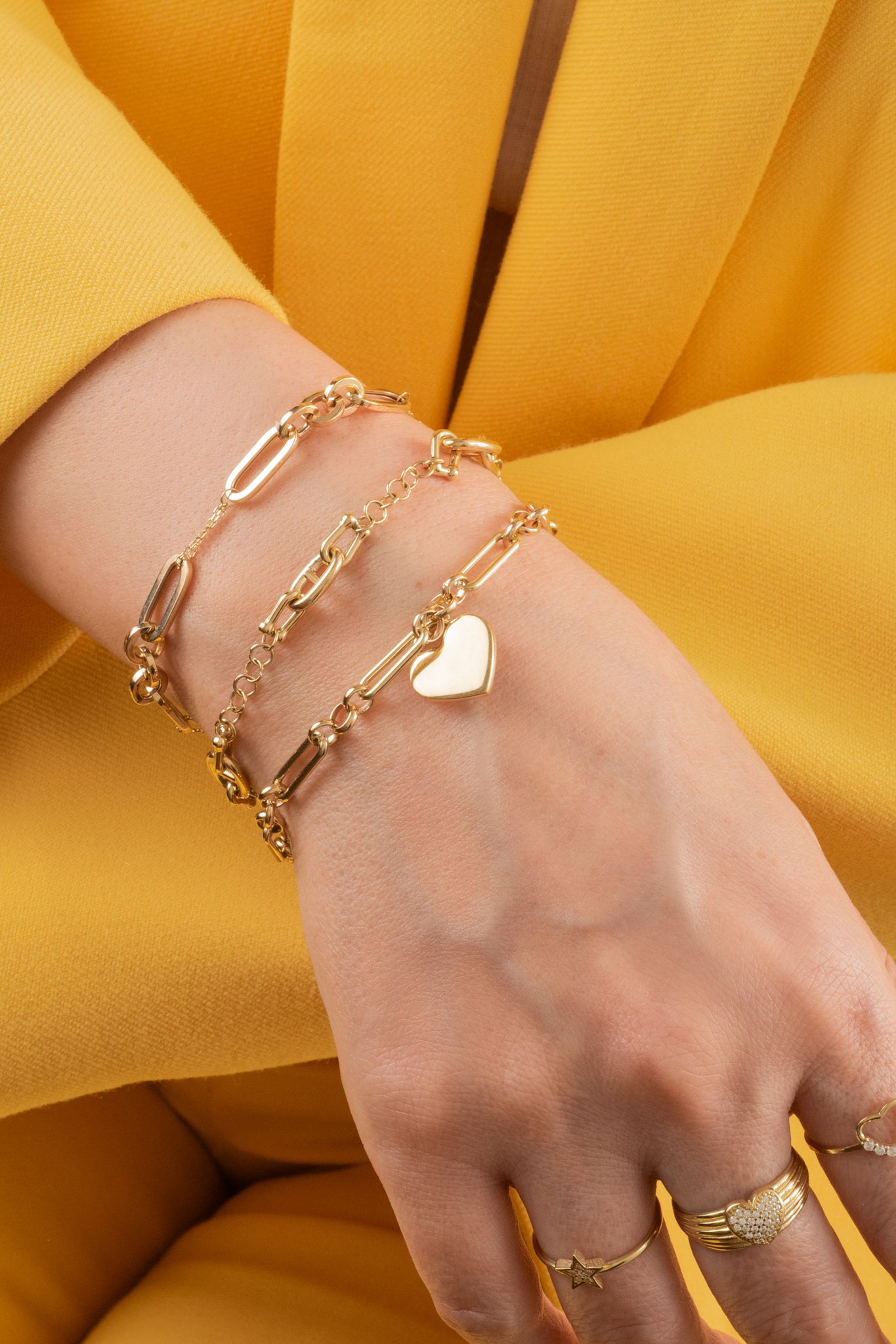 Pulsera de oro sólido en 10 kilates con dijes de eslabones enlazados variados intercalados.