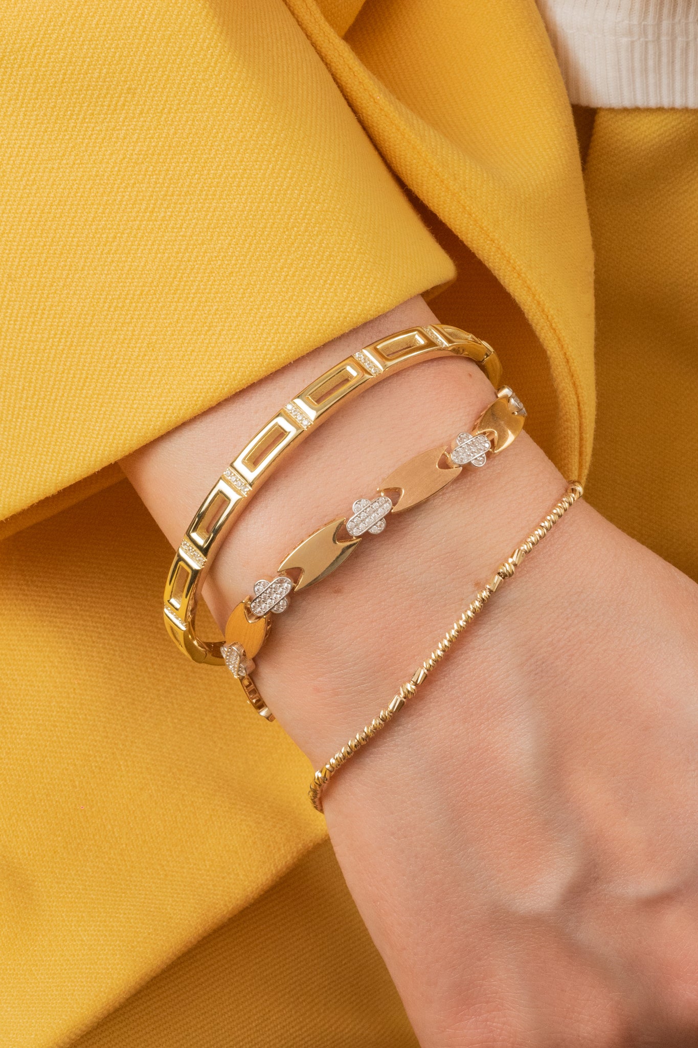 Pulsera de oro sólido en 10 kilates con aro de rectangulos huecos lisos y separación de zirconias en fila.