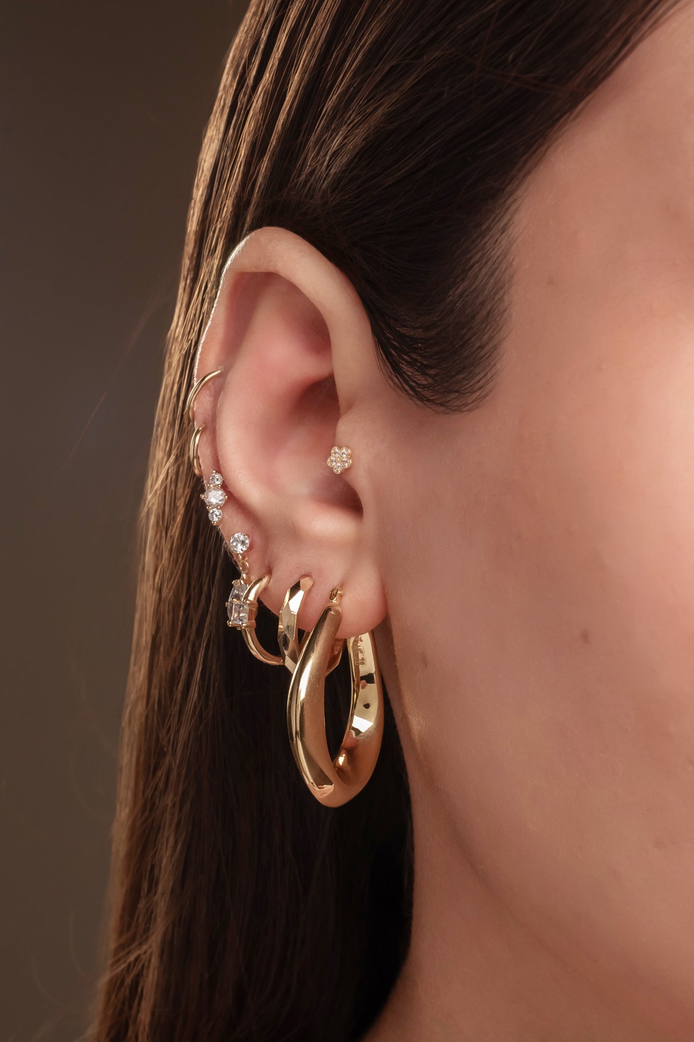 Arracada de oro sólido en 14 kilates con forma de U inflada irregular.