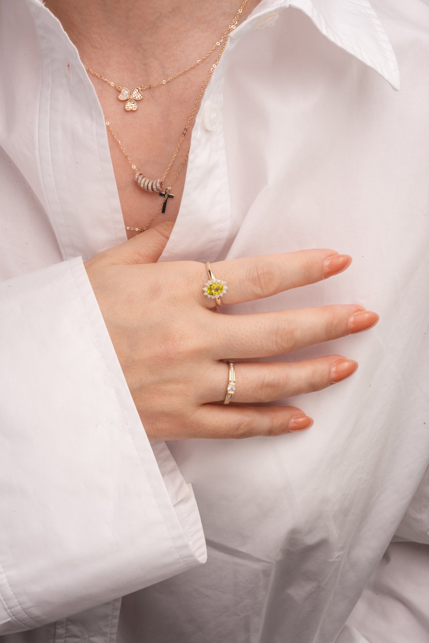 Anillo 10 kilates una piedra ovalada de color verde, un contorno de flor de zirconia blanca y un brazo delgado.