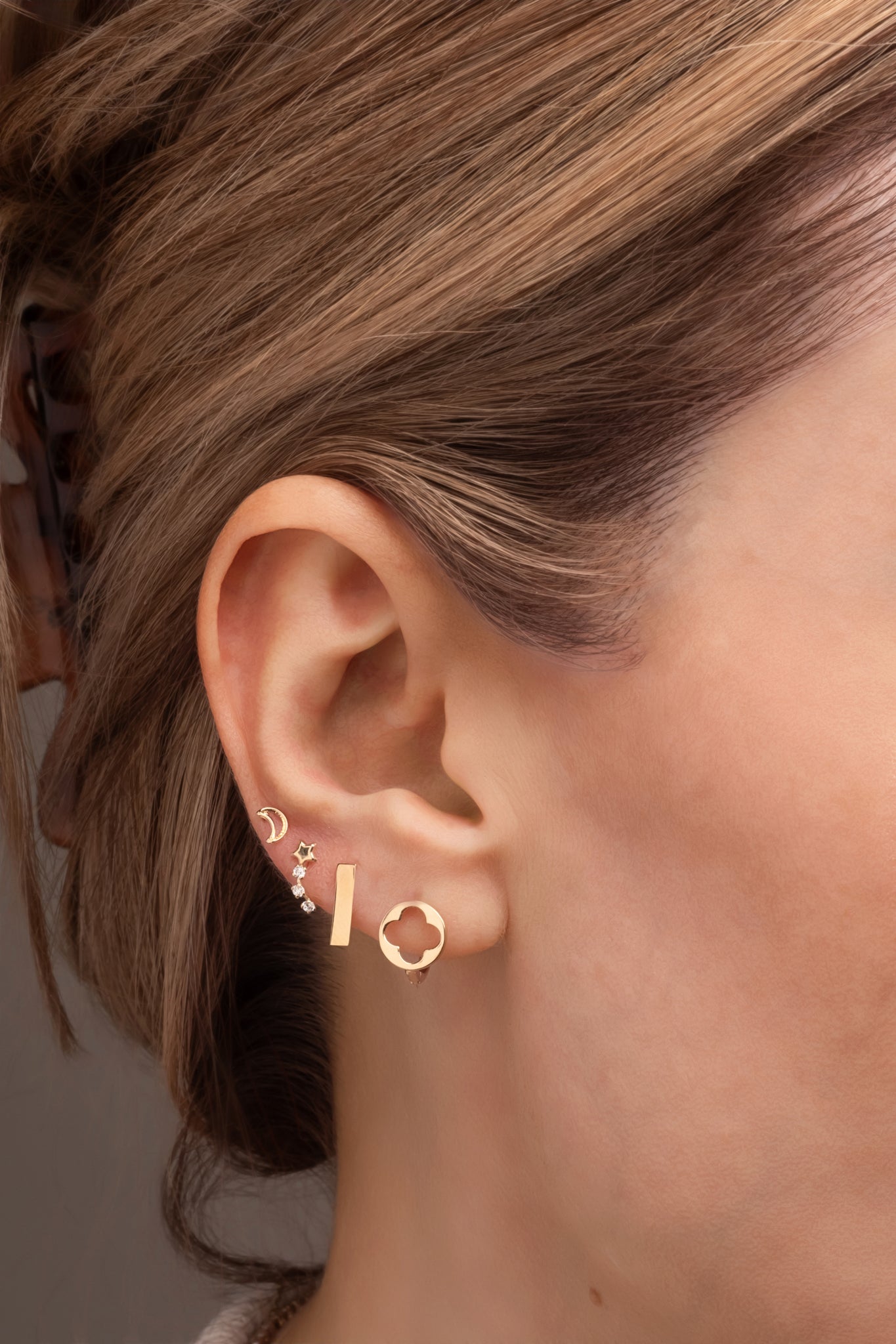 Huggie 10 kilates círculo y flor de cuatro pétalos hueco