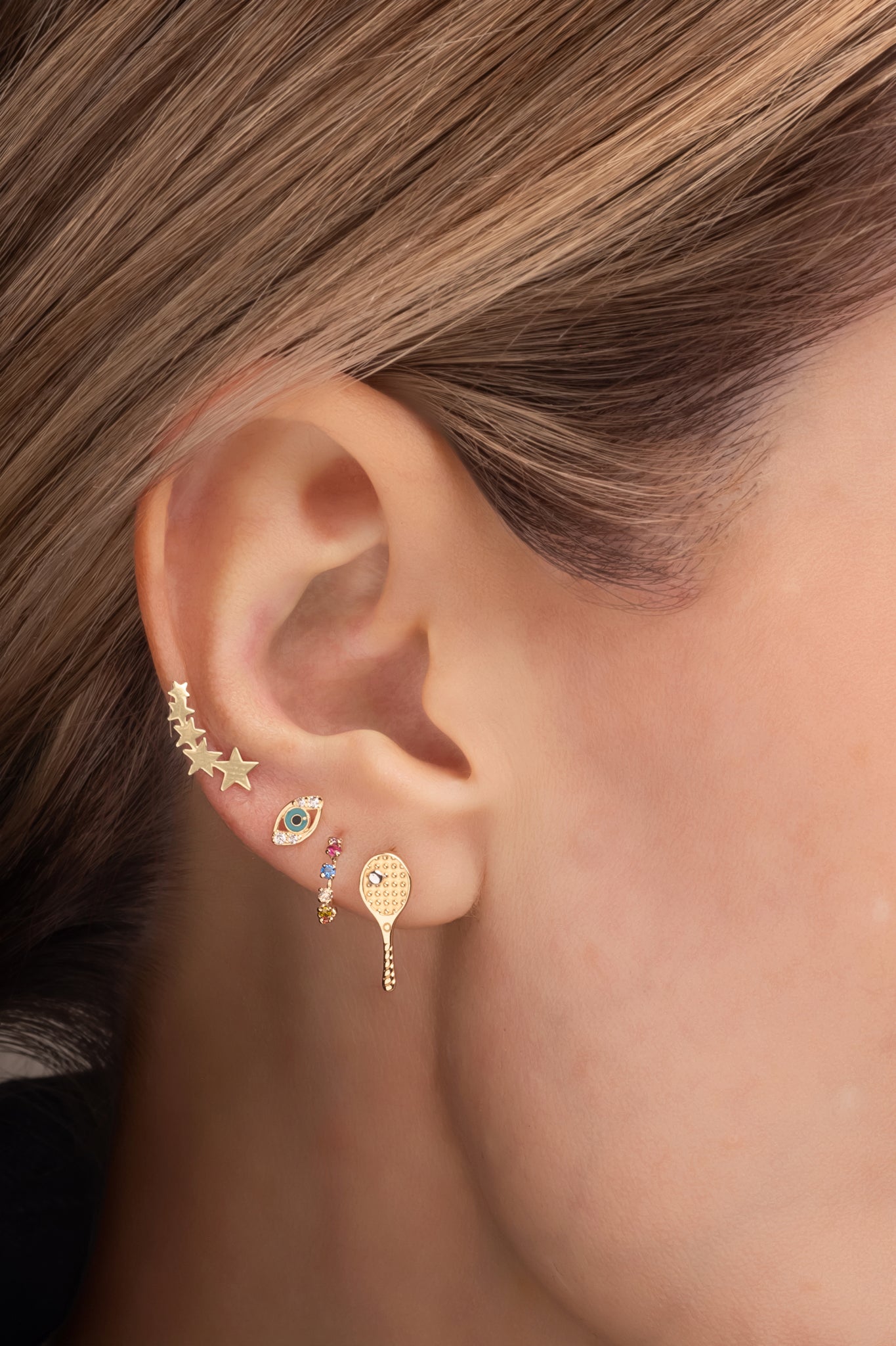 Arete de oro sólido en 14 kilates con forma de raqueta de tennis.