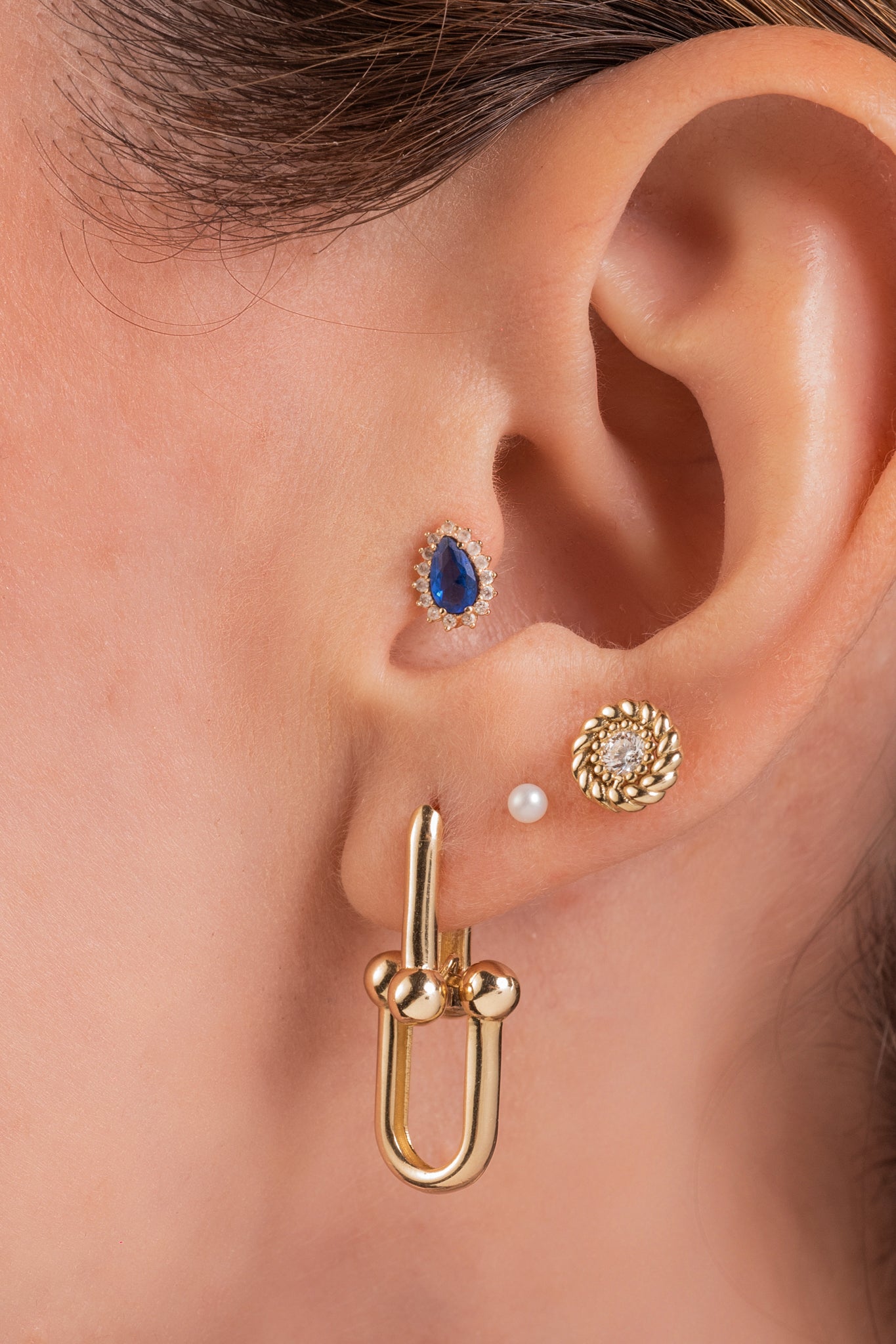 Arete de oro sólido en 10 kilates con zirconia blanca al centro y contorno liso estilo cuerda.