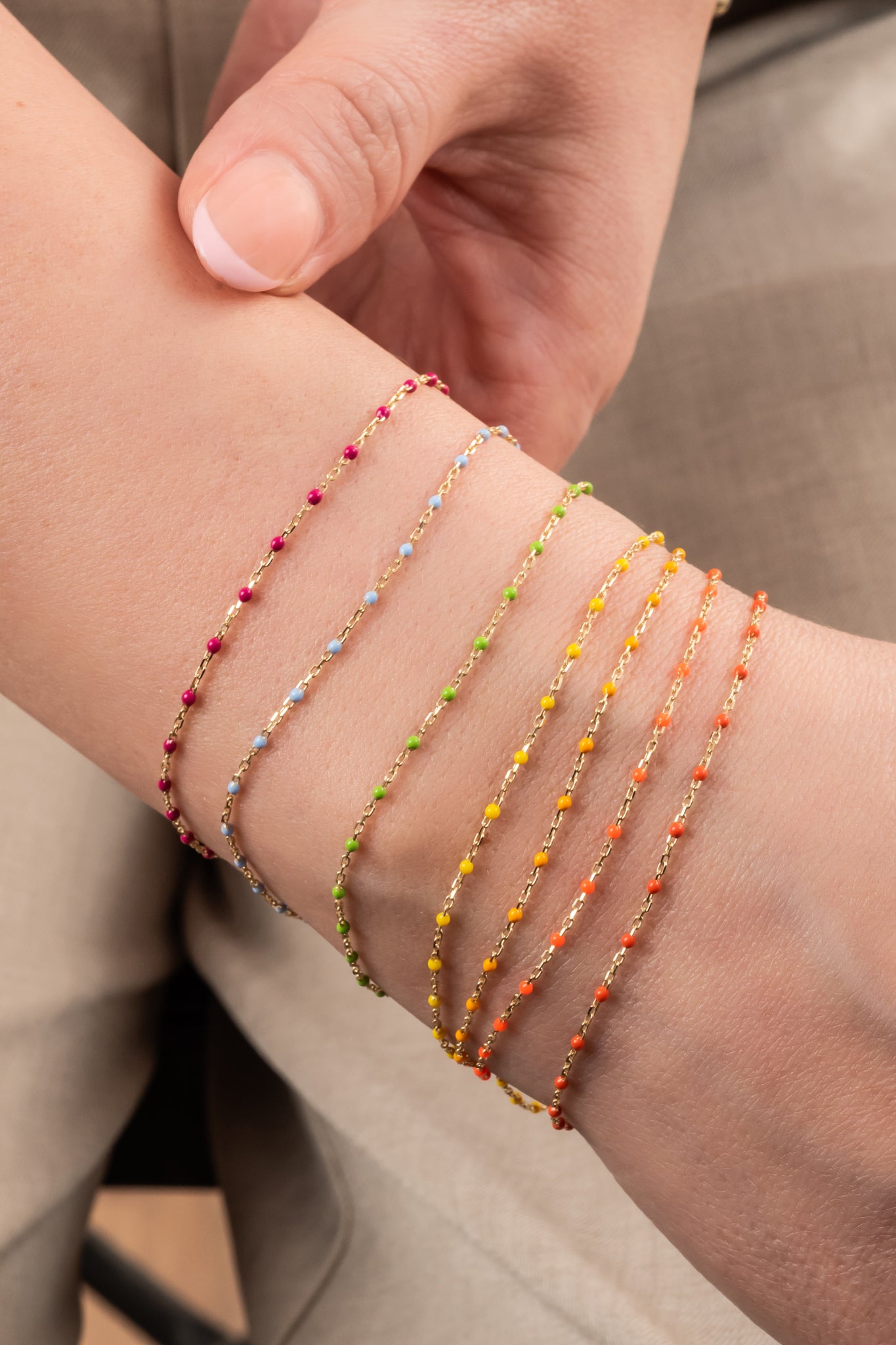 Pulsera de oro sólido en 10 kilates con bolitas esmaltadas naranja fosforecente.