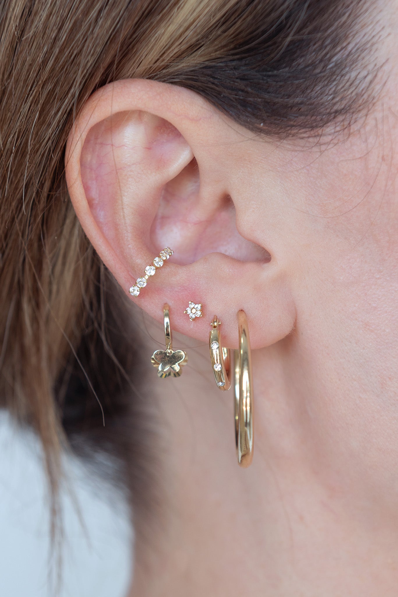 Arracada 10 kilates tubular con zirconias separadas.