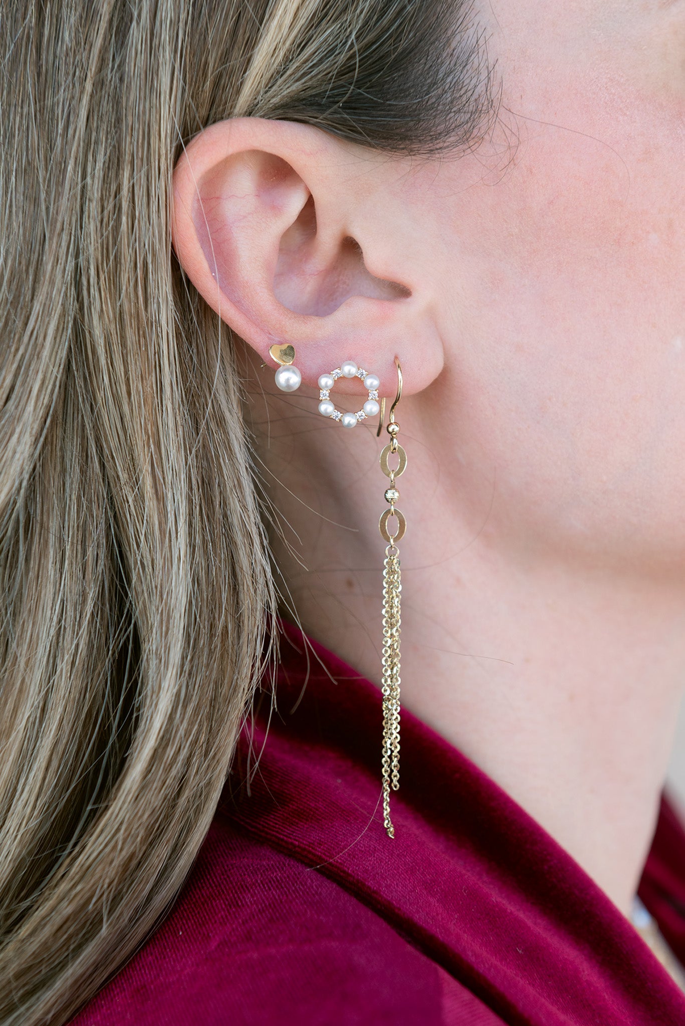 Arete 14 kilates con dijes de dos aros, con dijes de tres cadenas colgantes.