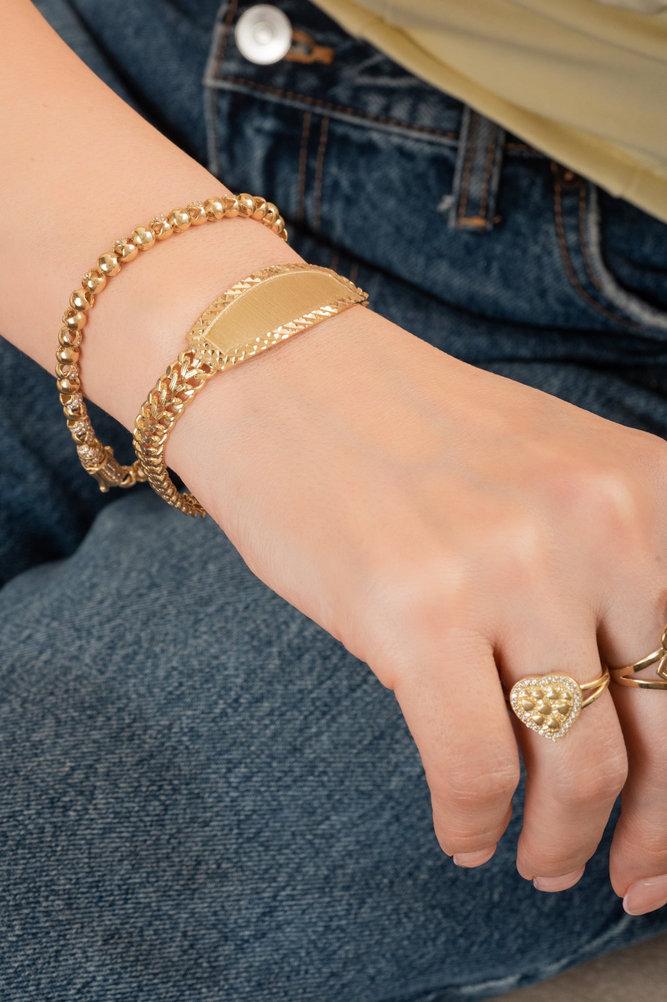 Pulsera de oro sólido en 10 kilates con dijes de bolas huecas lisas y zirconias intercaladas.