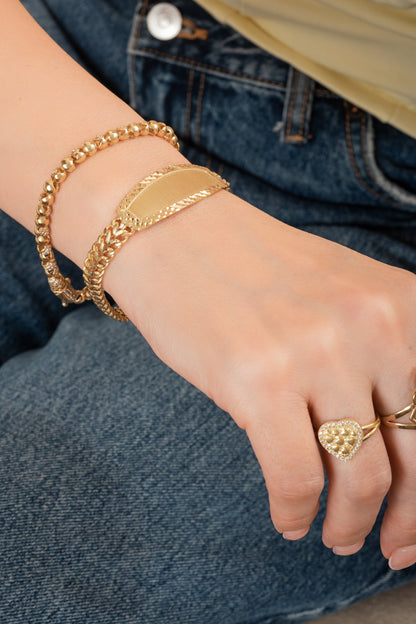 Pulsera de oro sólido en 10 kilates con dijes de bolas huecas lisas y zirconias intercaladas.