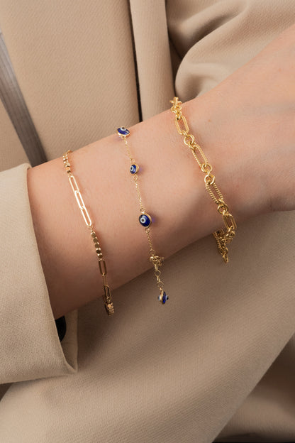 Pulsera de oro sólido en 10 kilates con dijes de ojos azules biselados