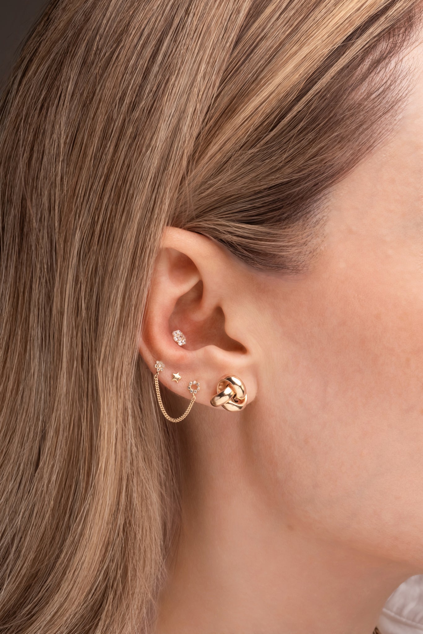 Arete de oro sólido en 14 kilates con tres vueltas de nudo oro amarillo liso.