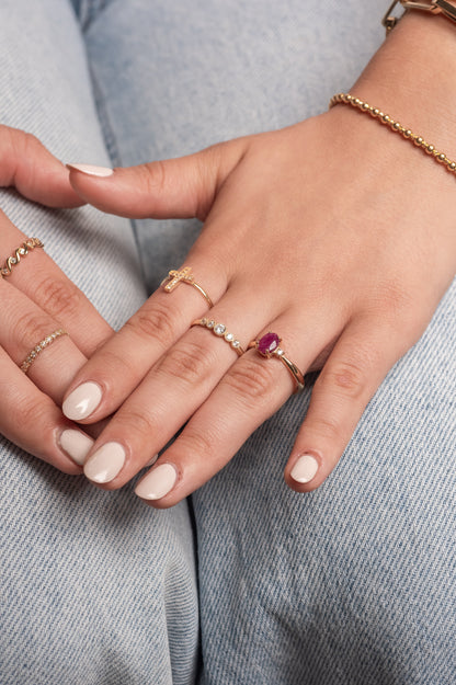 Anillo de oro sólido en 14 kilates con cinco zirconias, central grande y contorno de bolitas lisas minis.