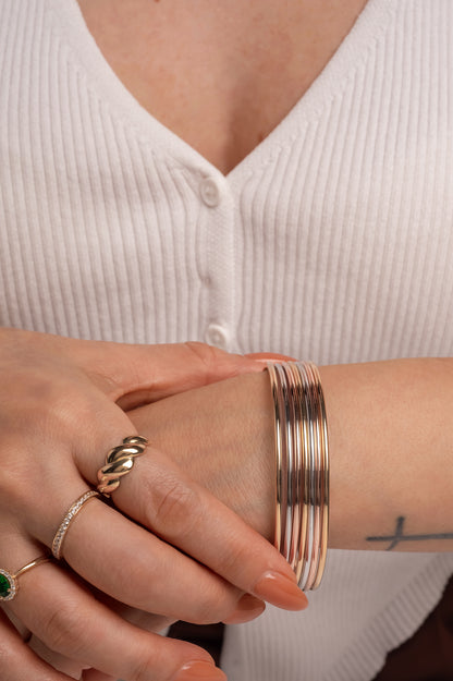 Aro semanario de oro sólido en 14 kilates con siete aros lisos de oro florentino tubulares.