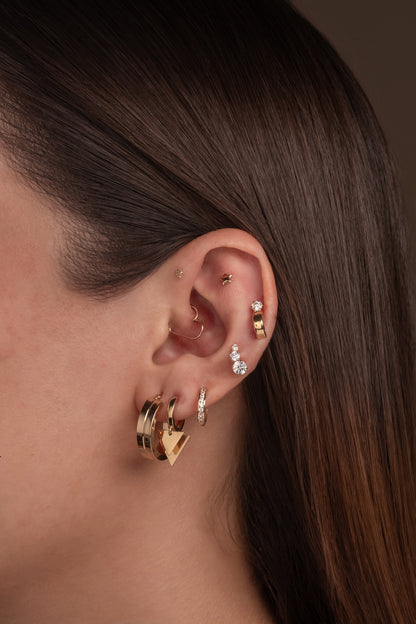 Huggie de oro sólido en 14 kilates con doble tiángulo en placa lisa.