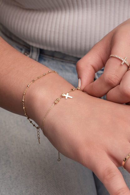 Pulsera de oro sólido en 10 kilates con cinco bolitas de estilo diamantado con un dije de cruz liso