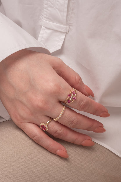 Anillo 10 kilates brazo triple, dos lisos con flores de zirconias rosas y centro churumbela con flor de zirconias rosas