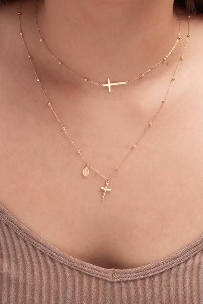 Gargantilla de oro sólido en 10 kilates con bolitas diamantadas y cruz placa lisa en horizontal.