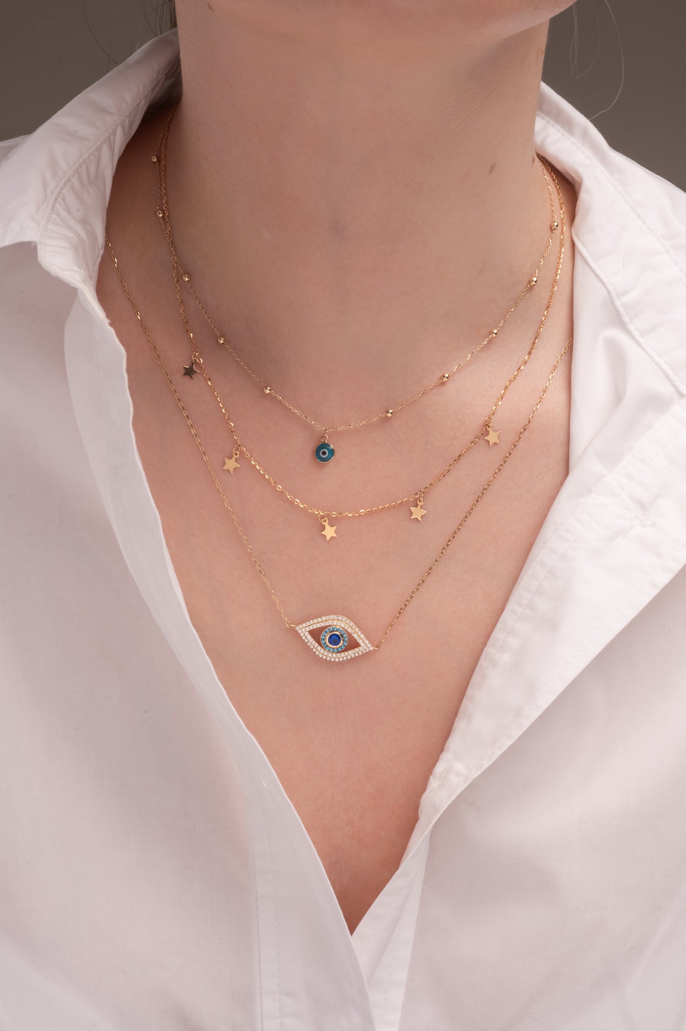 Gargantilla de oro sólido en 10 kilates con dije de ojo de zirconias blamcas, azules y centro zirconia azul grande.