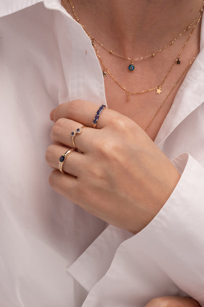 Anillo de oro sólido en 14 kilates con diamantes en forma de flores una arriba y una abajo, centro zafiro.