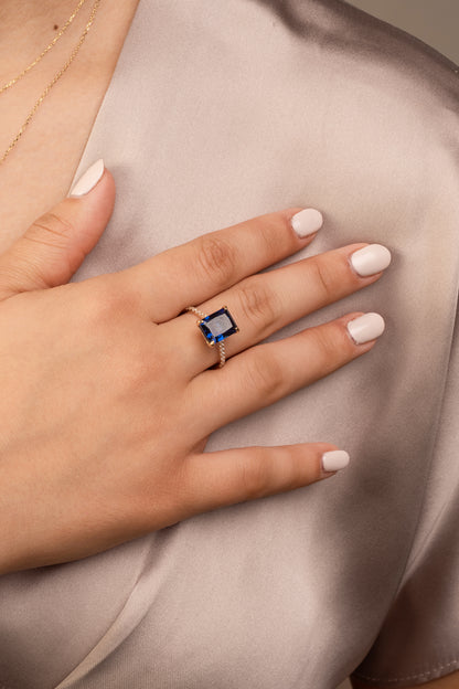 Anillo en 14 kilates con corte baguette zirconia azul con brazo de zirconia blanca.