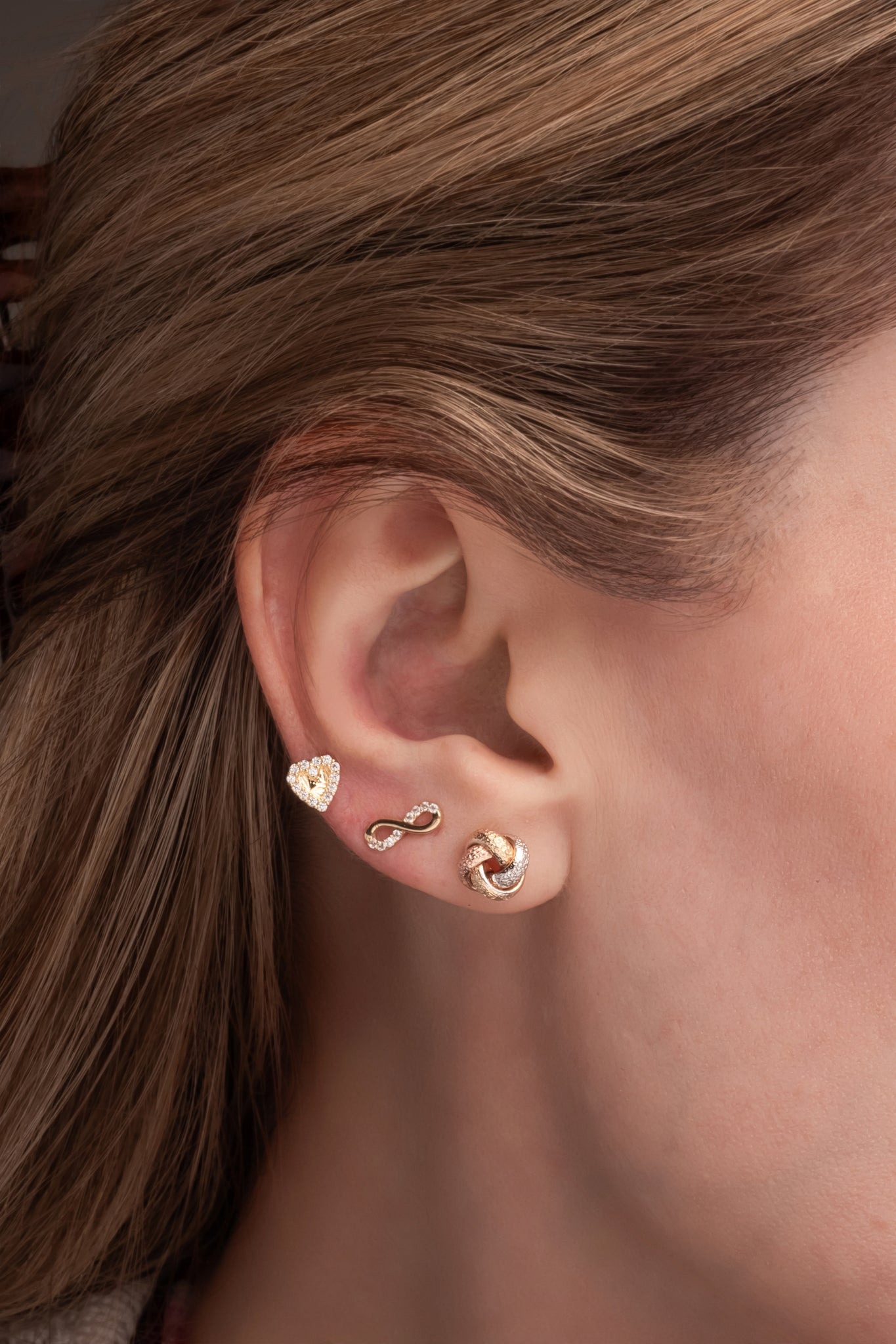 Arete de oro sólido en 14 kilates con infinito mitad liso y miatd zirconias.