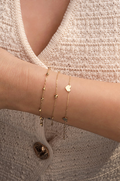 Pulsera 10 kilates dos bolitas medianas lisas y dos pequeñas lisas.