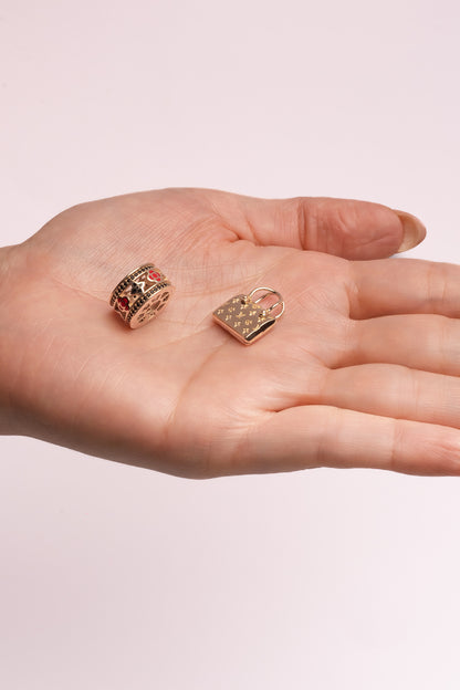 Dije 10 kilates forma de cilindro y flores esmaltadas rojo, negro y orillas de zirconias negras