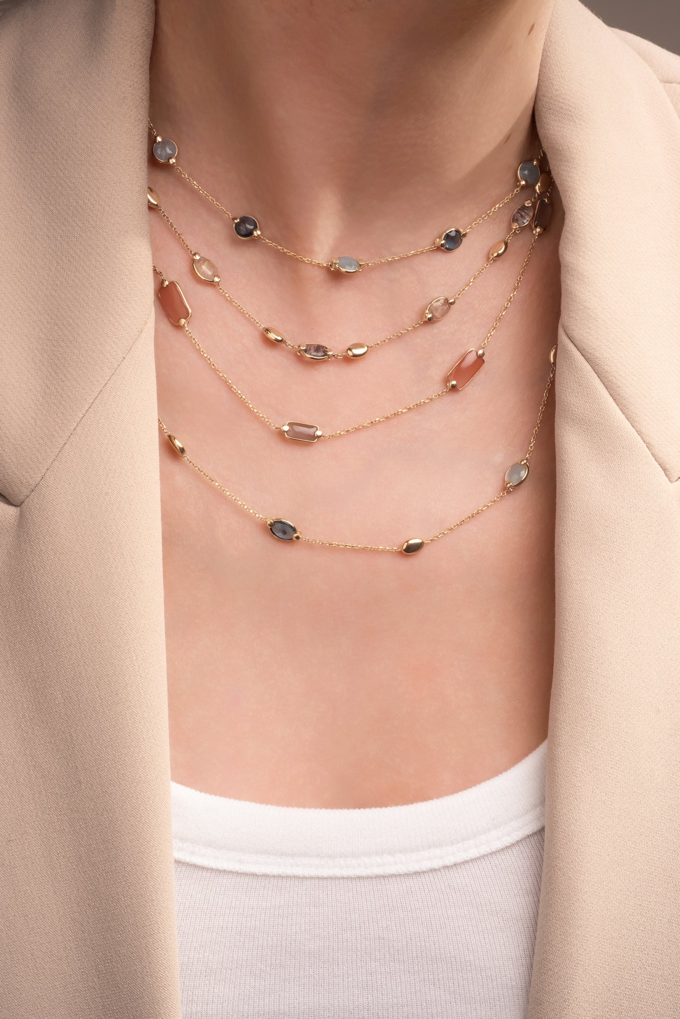 Gargantilla de oro sólido en 14 kilates con dijes de ilolita, aguamarina ovaladas y semillas lisas de oro amarillo.