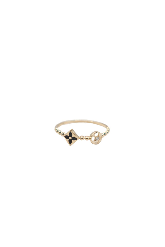 Anillo de 10 kilates con brazo de bolitas, círculo floral y rombo con flor esmaltada negra..png