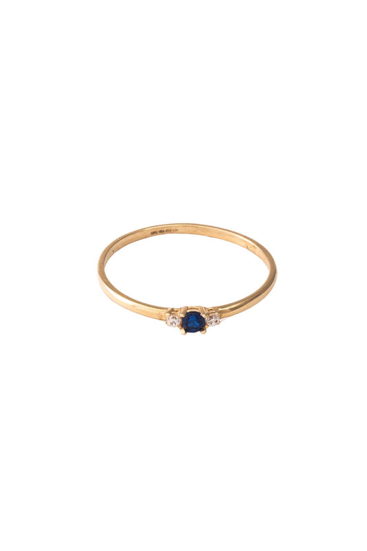 Anillo de oro sólido en 10 kilates con brazo liso y zirconias al centro, dos blancas y una azul rey..png