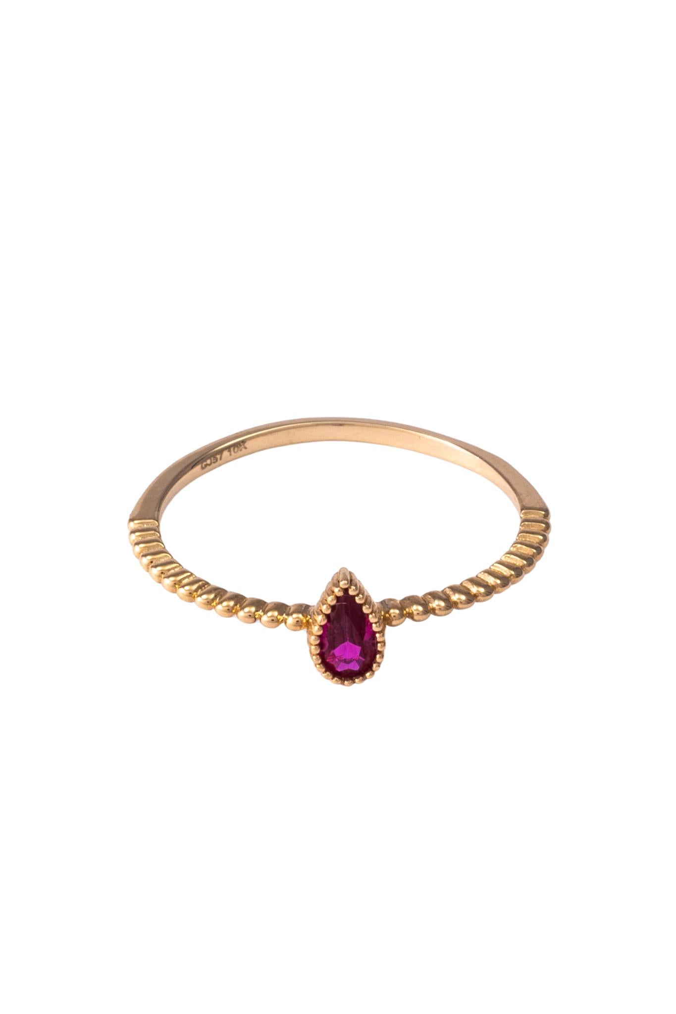 Anillo de oro solido en 10 kilates con un contorno de bolitas y una gota rosa fuerte en el centro.png