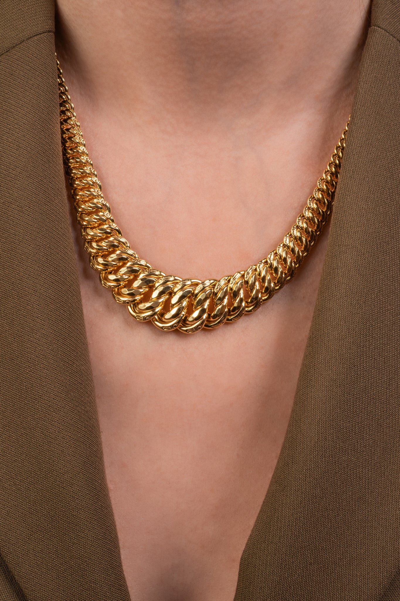 Gargantilla de oro sólido en 10 kilates con forma gruesa decreciente de nudos enlazados.