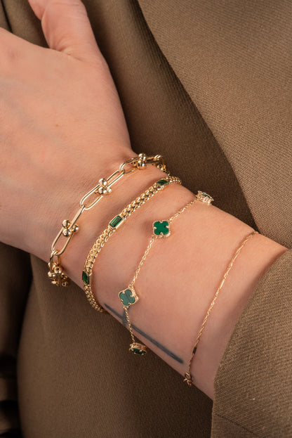 Pulsera de oro sólido en 10 kilates con eslabón de esferas enlazadas y zirconias rectangulares verdes intercaladas.