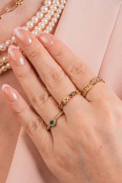 Anillo de oro sólido en 10 kilates con zirconia central verde contorno zirconias minis blancas y brazo con media churumbela zirconias biseladas.