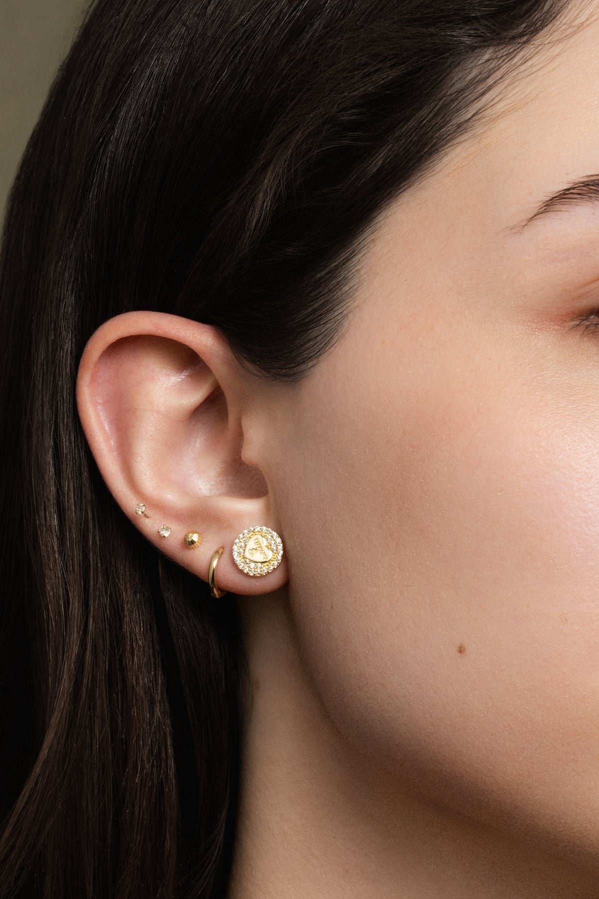 Arete 10 kilates círculo de zirconias y corazón liso con letras.