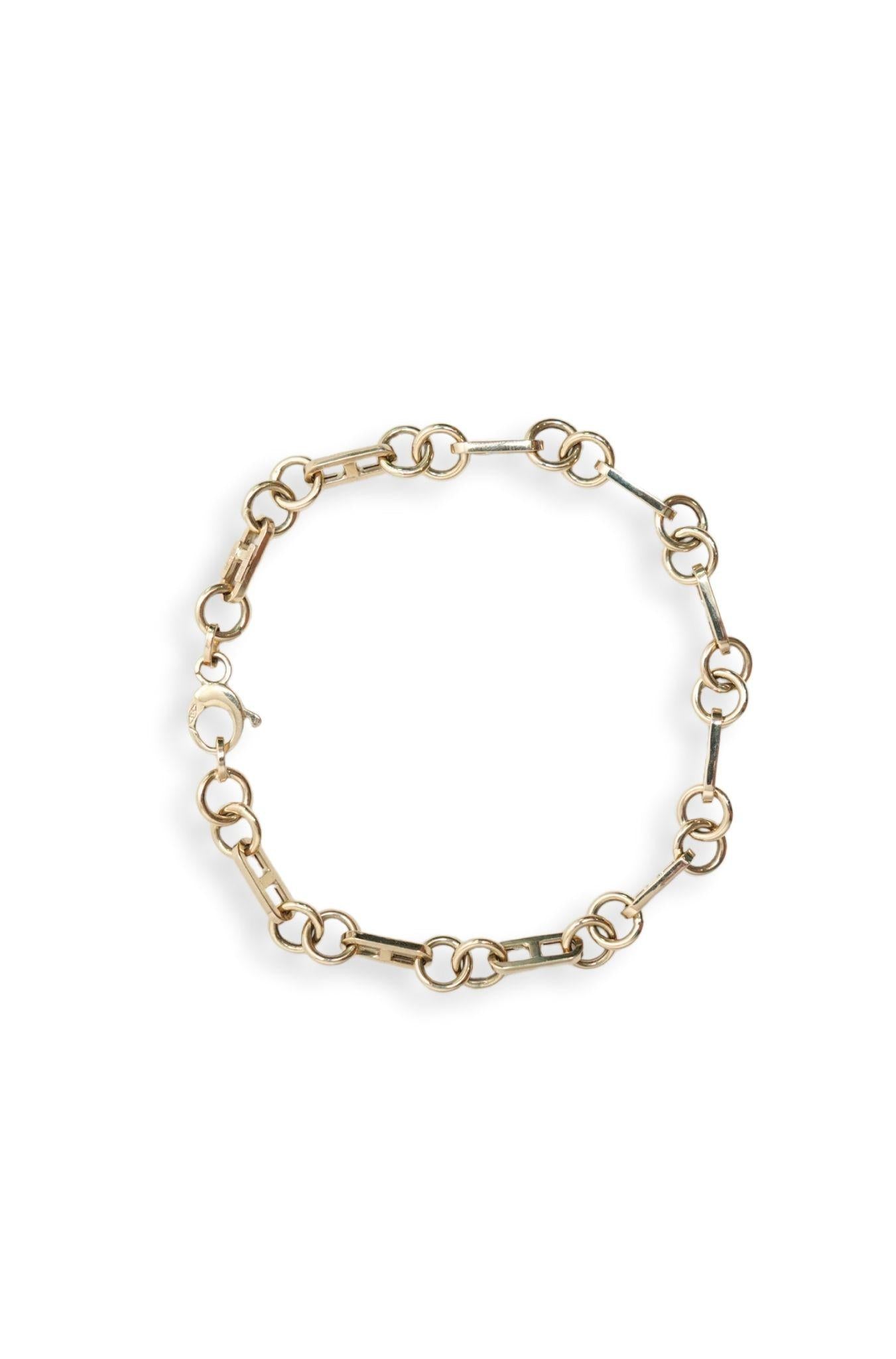 Pulsera de oro sólido en 10 kilates con eslabón seguro y dos aros lisos.png